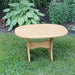 Oval Side Table in a grassy area with plants in the background - poly luxe - woodgrain birchwood