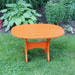 Oval Side Table in a grassy area with plants in the background - poly luxe - orange