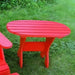Red oval side table set on a grassy area