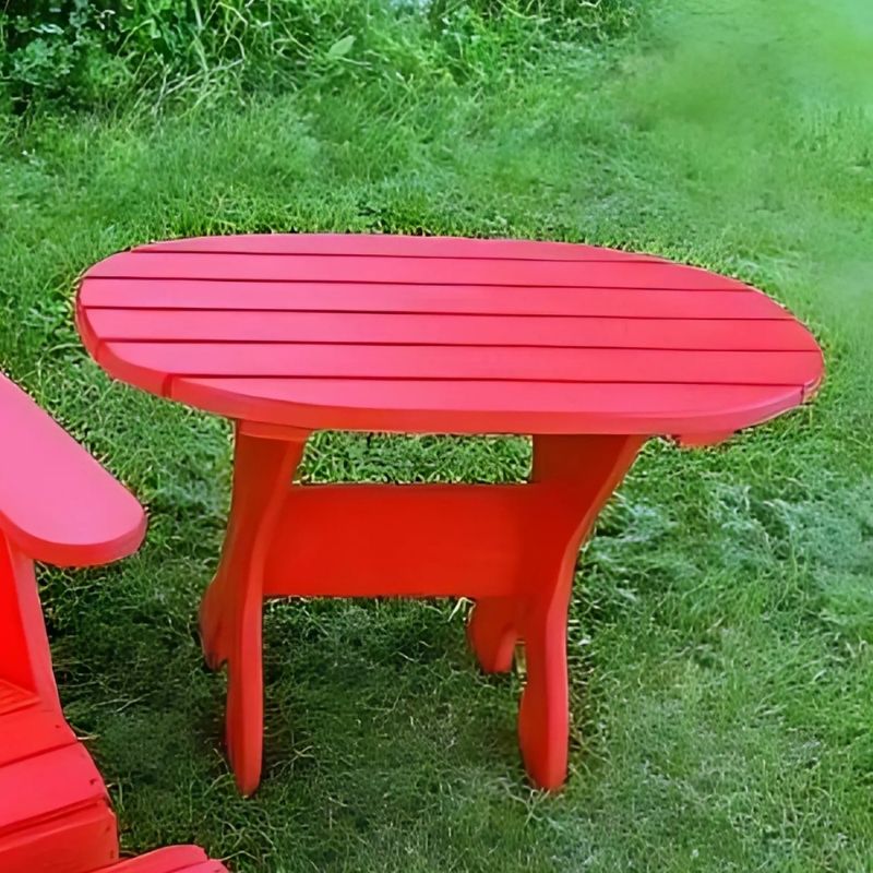 Red oval side table set on a grassy area
