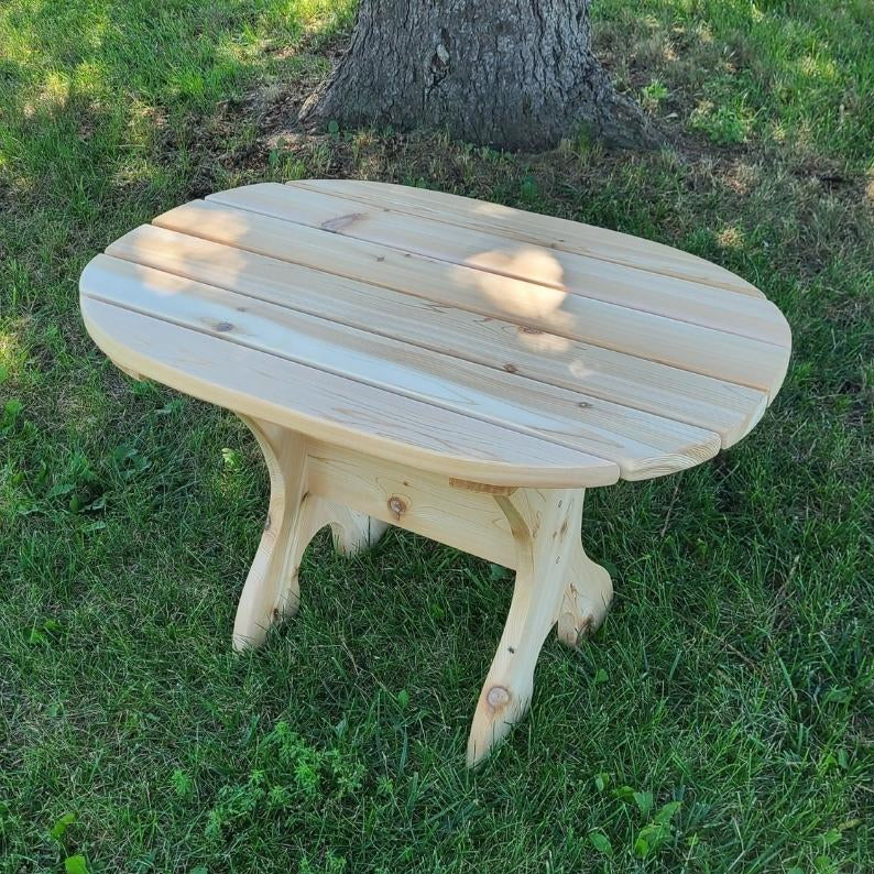 Oval side tableon grass with a tree in the background