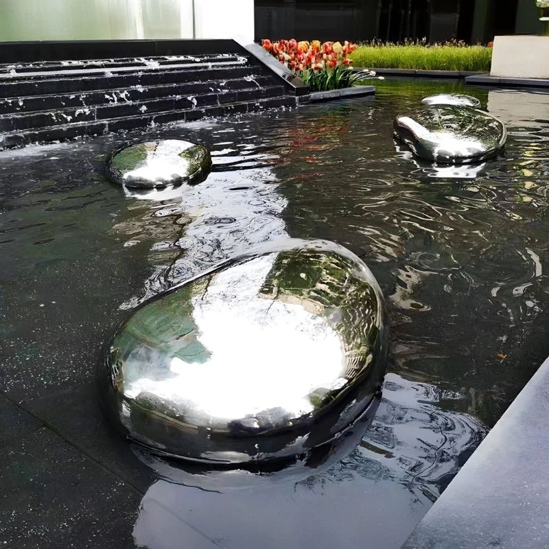 Pebble Organic Outdoor Steel Sculpture in a water pond setting