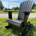 Royal Rocking Adirondack Chair (Large) on grass with a road and trees in the background