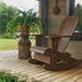 Royal Rocking Adirondack Chair (Large) on a porch with a potted plant and garden view - poly luxe - woodgrain brazilian walnut
