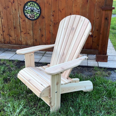 Royal Upright Adirondack Chair, on a grassy area with a wooden fence in the background