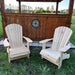 Two Royal Upright Adirondack Chair, in front of a wooden structure with a scenic background.