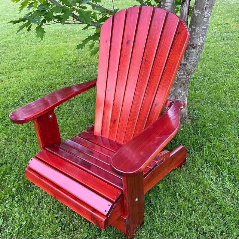 Red Royal Upright Adirondack Chair, on a grassy area with a tree in the background