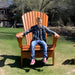 Person sitting on Traditional Giant chair outdoors on a grassy area.